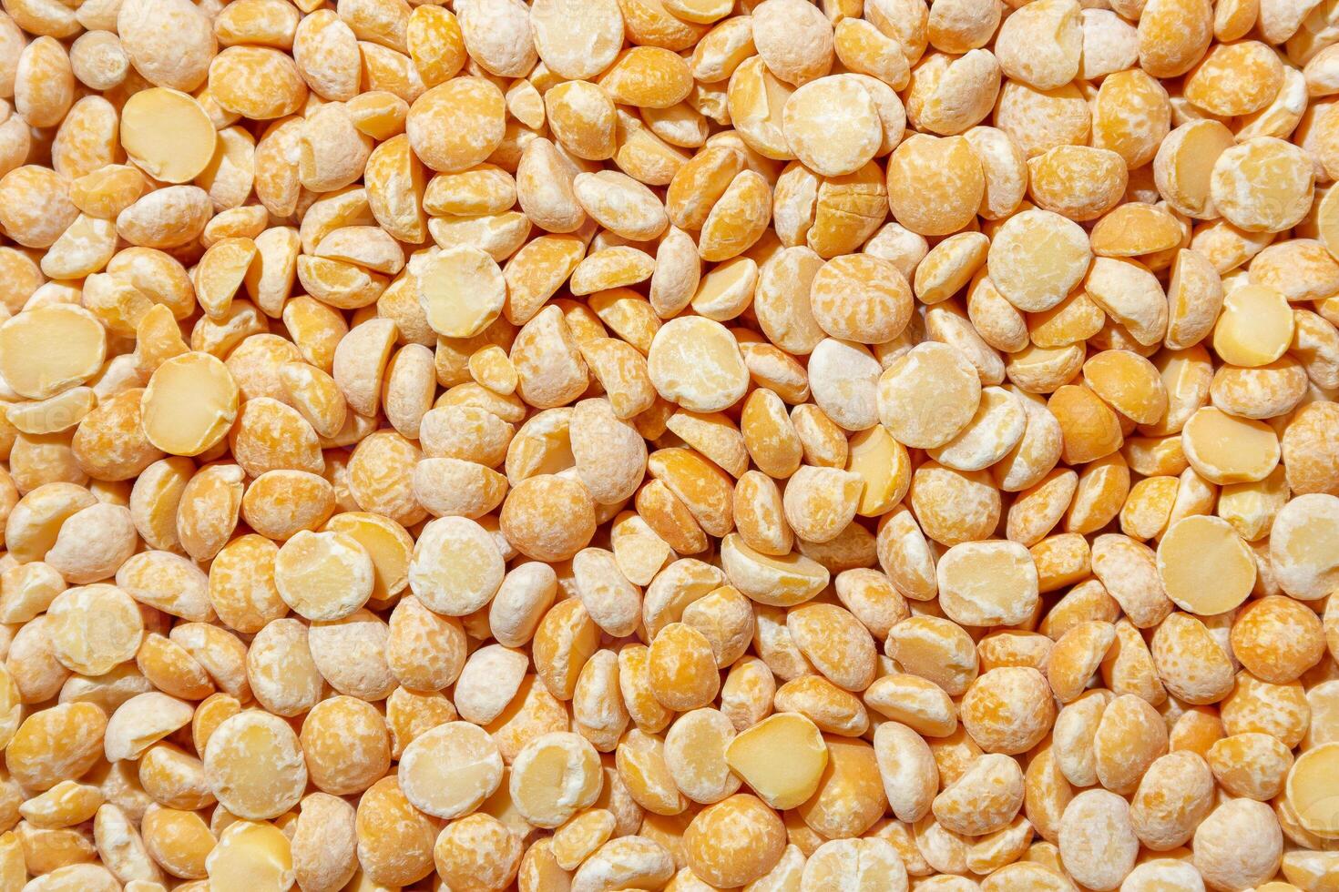 Uncooked Polished Split Peas Background. A Culinary Canvas of Dry Yellow Peas, Creating a Lively and Textured Background for Gourmet Cooking. Scattered Raw Polished Peas. Healthy Eating Ingredients photo