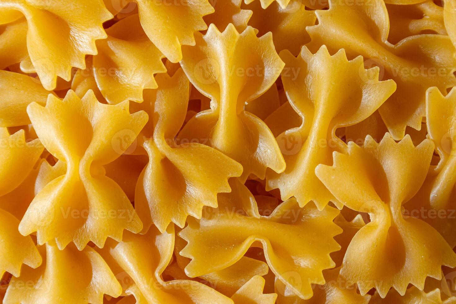 Uncooked Farfalle Pasta. A Culinary Canvas of Bow-Tie Macaroni, Creating a Lively and Textured Background for Gourmet Cooking. Dry Pasta. Raw Macaroni - Top View, Flat Lay photo