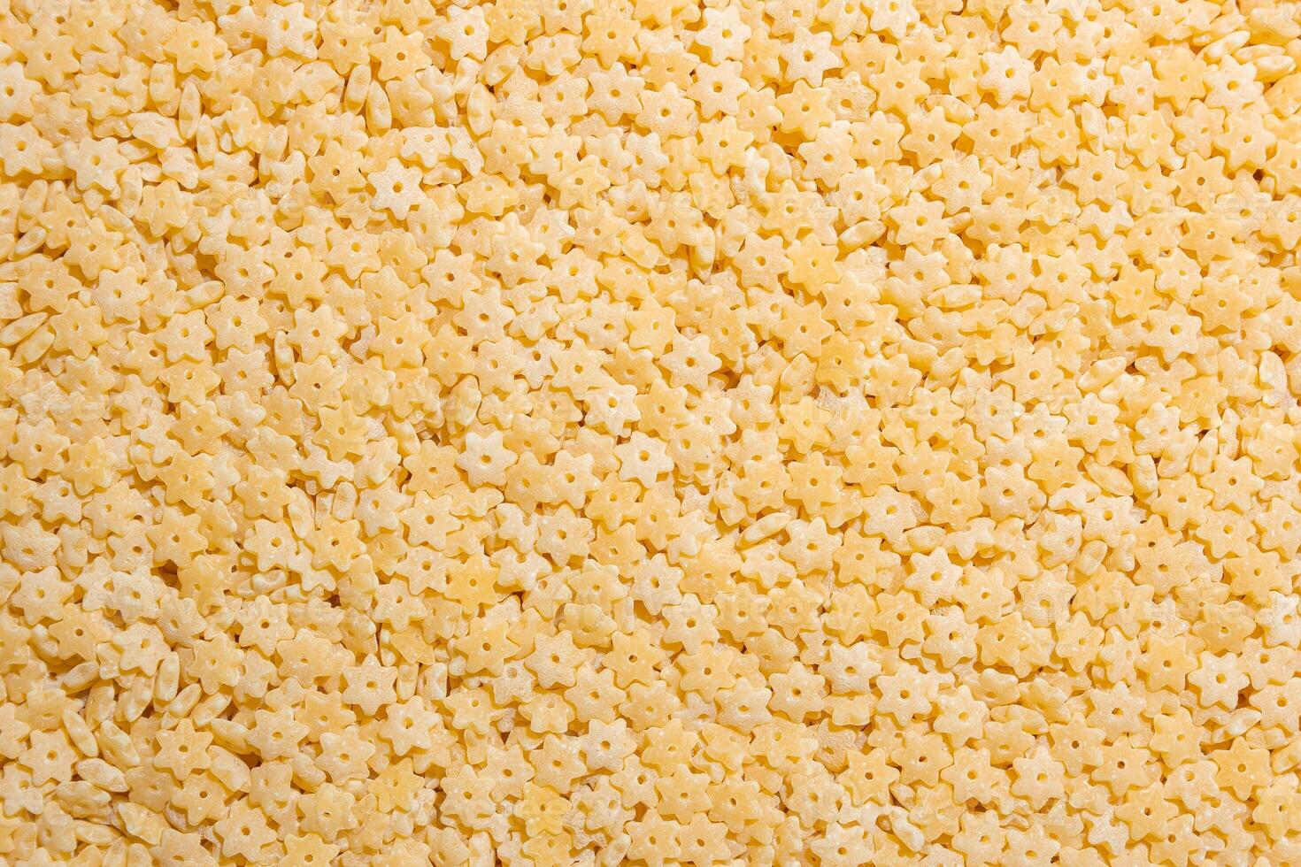 Uncooked Stelline Pasta. A Culinary Canvas of Stelline Macaroni, Creating a Lively and Textured Background for Gourmet Cooking. Dry Pasta. Raw Macaroni - Top View, Flat Lay photo