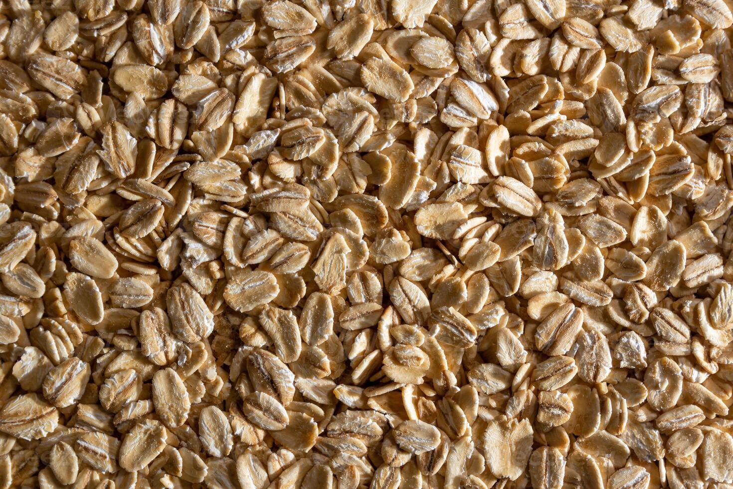Uncooked Oat Flakes background - Top View, Flat Lay. Scattered Dry and Raw Oat Flakes. Healthy Breakfast and Diet Eating Ingredients photo
