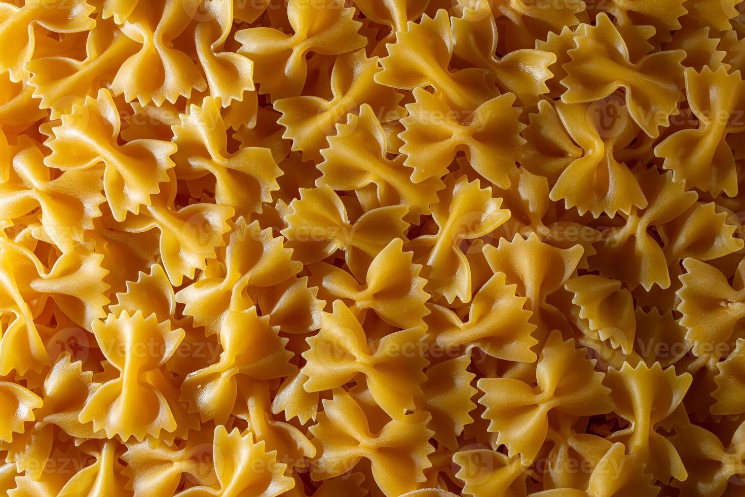 Uncooked Farfalle Pasta. A Culinary Canvas of Bow-Tie Macaroni, Creating a Lively and Textured Background for Gourmet Cooking. Dry Pasta. Raw Macaroni - Top View, Flat Lay photo