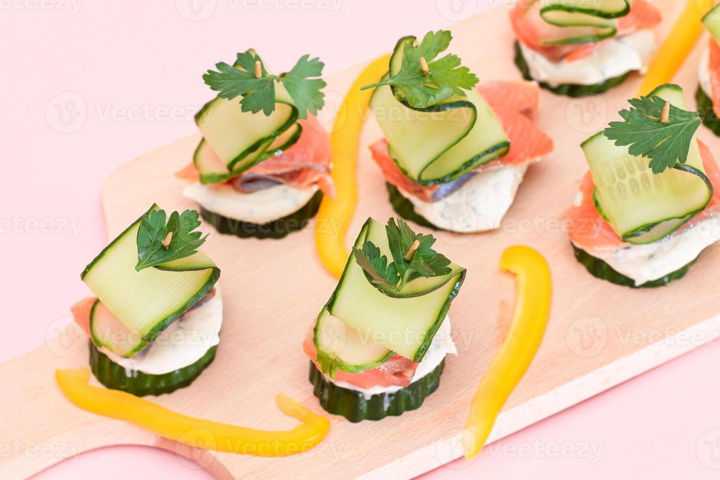 Canapes without Bread with Fresh Salmon, Cucumber and Cream Cheese on Wooden Cutting Board. Easy Breakfast. Diet Food. Quick and Healthy Sandwiches. Healthy Snacks with Tasty Fillings photo