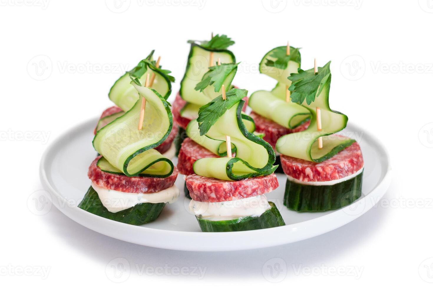 Canapes without Bread with Salami, Cucumber, Greens and Cream Cheese on White Plate - Isolated on White. Easy Breakfast. Diet Food. Quick and Healthy Sandwiches. Healthy Snacks with Tasty Fillings photo