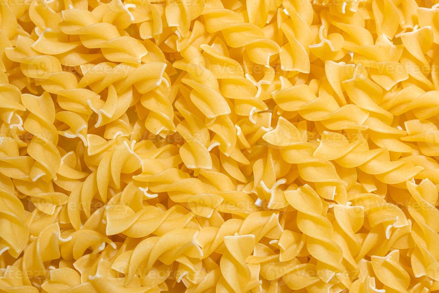 Uncooked Fusilli Pasta. A Culinary Canvas of Spiral Macaroni, Creating a Lively and Textured Background for Gourmet Cooking. Dry Pasta. Raw Macaroni - Top View, Flat Lay photo