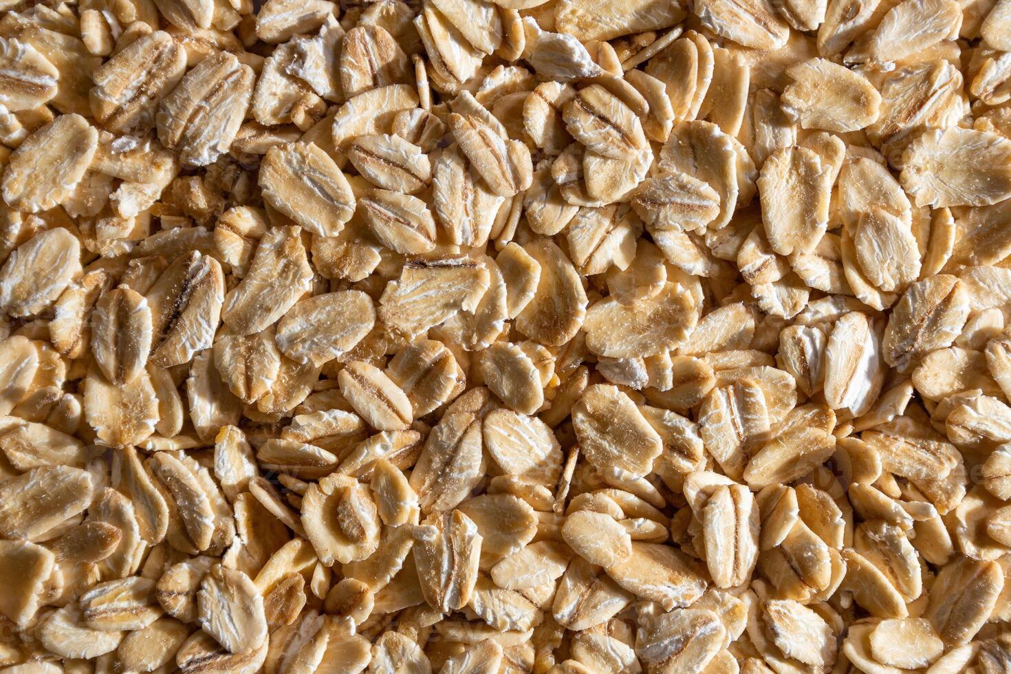 Uncooked Oat Flakes background - Top View, Flat Lay. Scattered Dry and Raw Oat Flakes. Healthy Breakfast and Diet Eating Ingredients photo