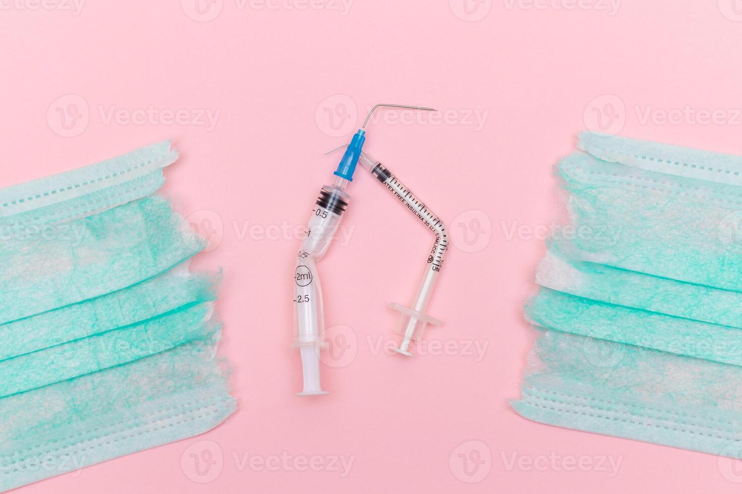 Anti Vaccine Movement and Anti Mask Concept - Broken Medical Syringe and Green Torn Medical Face Mask on the Pink Background. Pandemic and Lockdown End - Top View, Flat Lay photo