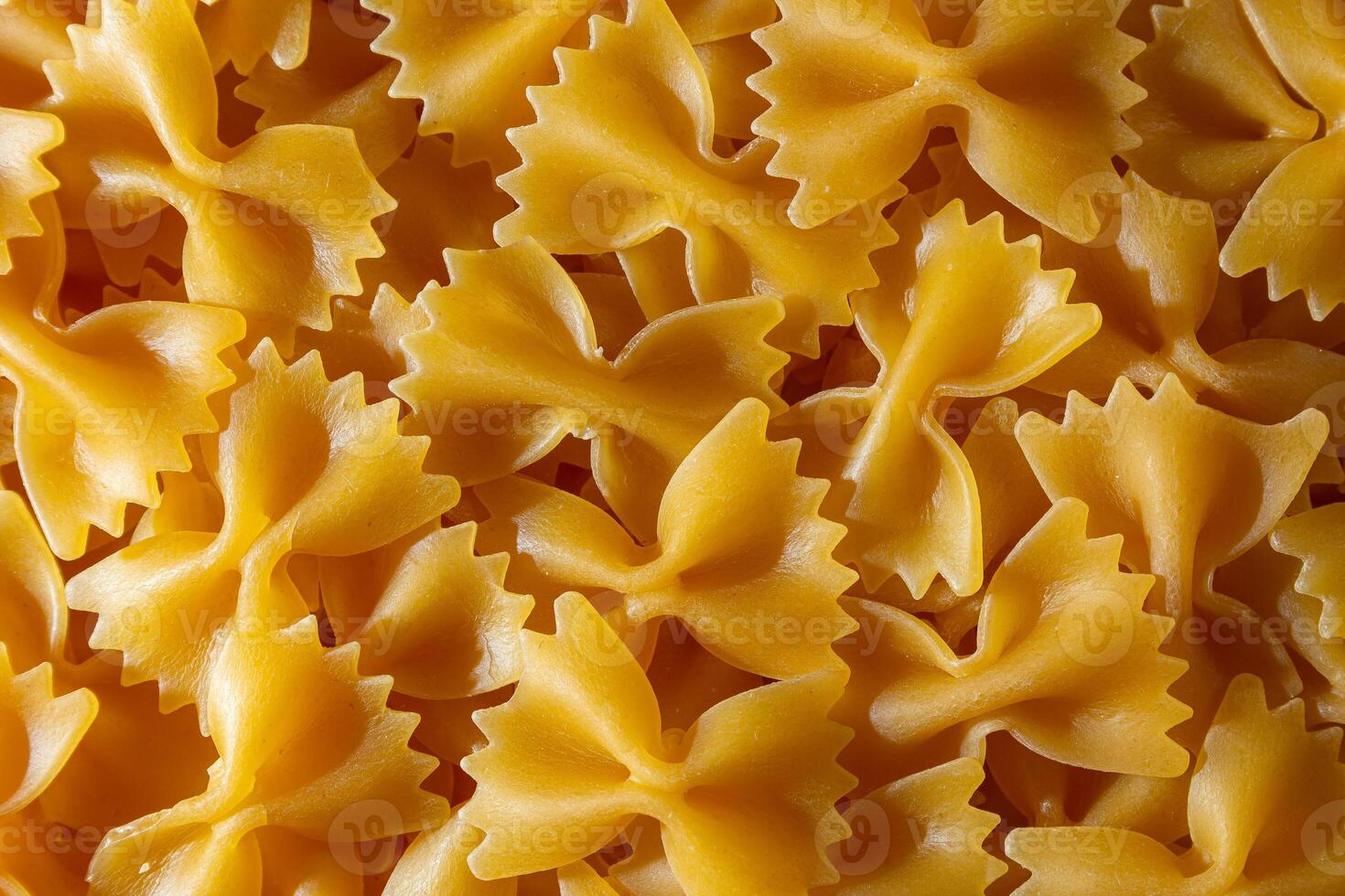 Uncooked Farfalle Pasta. A Culinary Canvas of Bow-Tie Macaroni, Creating a Lively and Textured Background for Gourmet Cooking. Dry Pasta. Raw Macaroni - Top View, Flat Lay photo