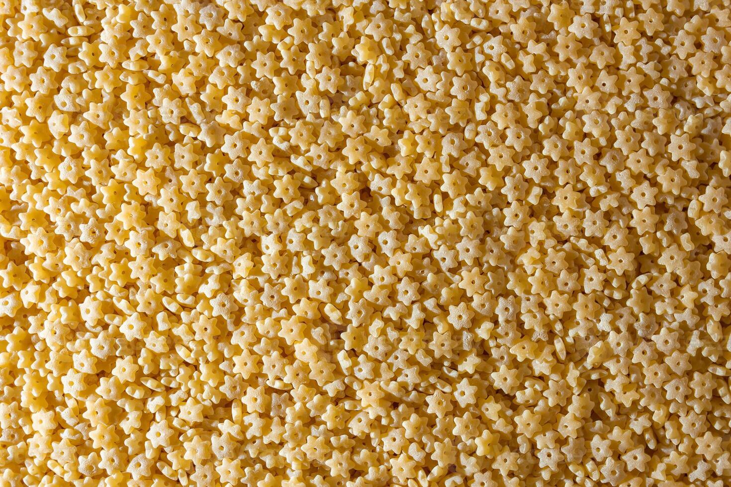 Uncooked Stelline Pasta. A Culinary Canvas of Stelline Macaroni, Creating a Lively and Textured Background for Gourmet Cooking. Dry Pasta. Raw Macaroni - Top View, Flat Lay photo
