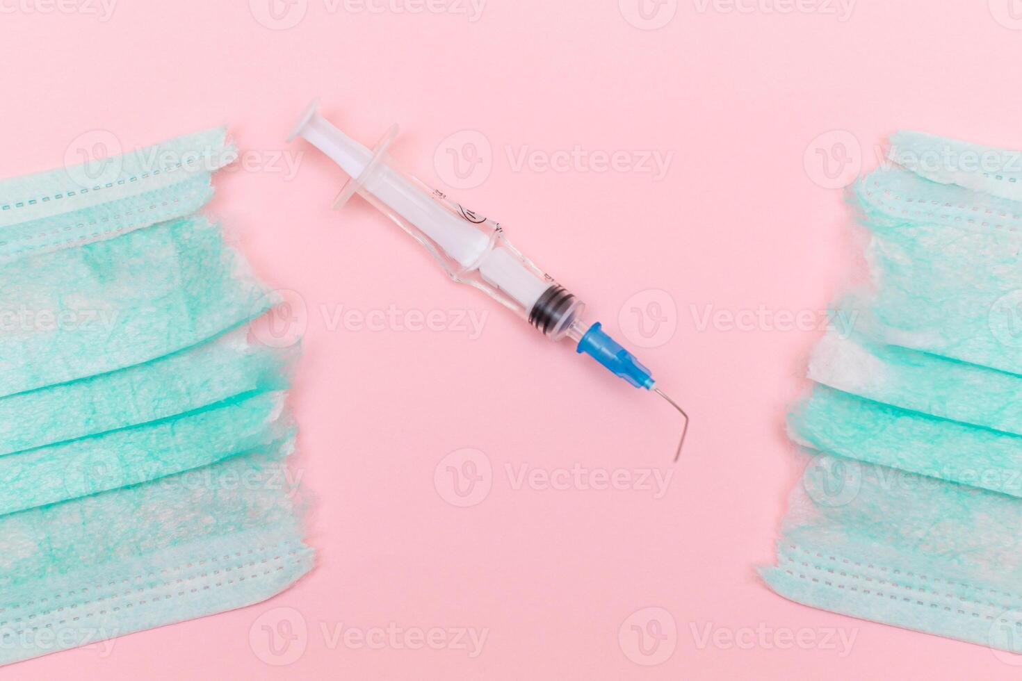 Anti Vaccine Movement and Anti Mask Concept - Broken Medical Syringe and Green Torn Medical Face Mask on the Pink Background. Pandemic and Lockdown End - Top View, Flat Lay photo