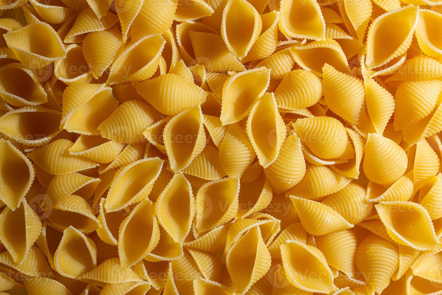 Uncooked Conchiglie Pasta. A Culinary Canvas of Conchiglie Macaroni, Creating a Lively and Textured Background for Gourmet Cooking. Dry Pasta. Raw Macaroni - Top View, Flat Lay photo