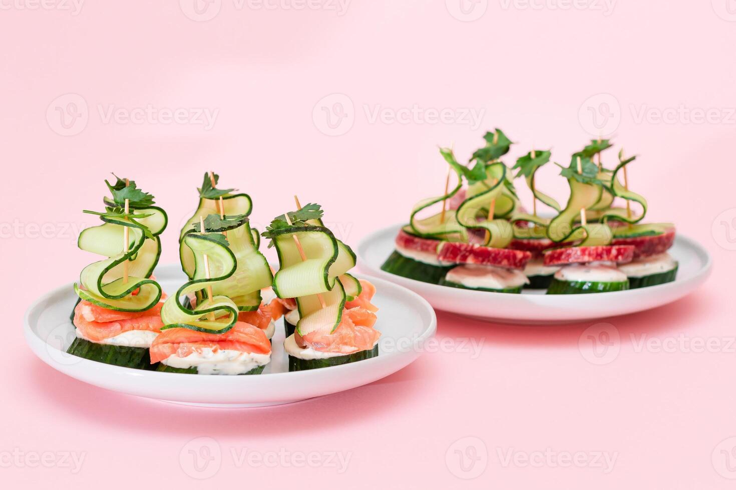 Canapes without Bread with Fresh Salmon, Salami, Cucumber, Greens and Cream Cheese on White Plate - Isolated on White. Easy Breakfast. Diet Food. Quick and Healthy Sandwiches and Snacks photo
