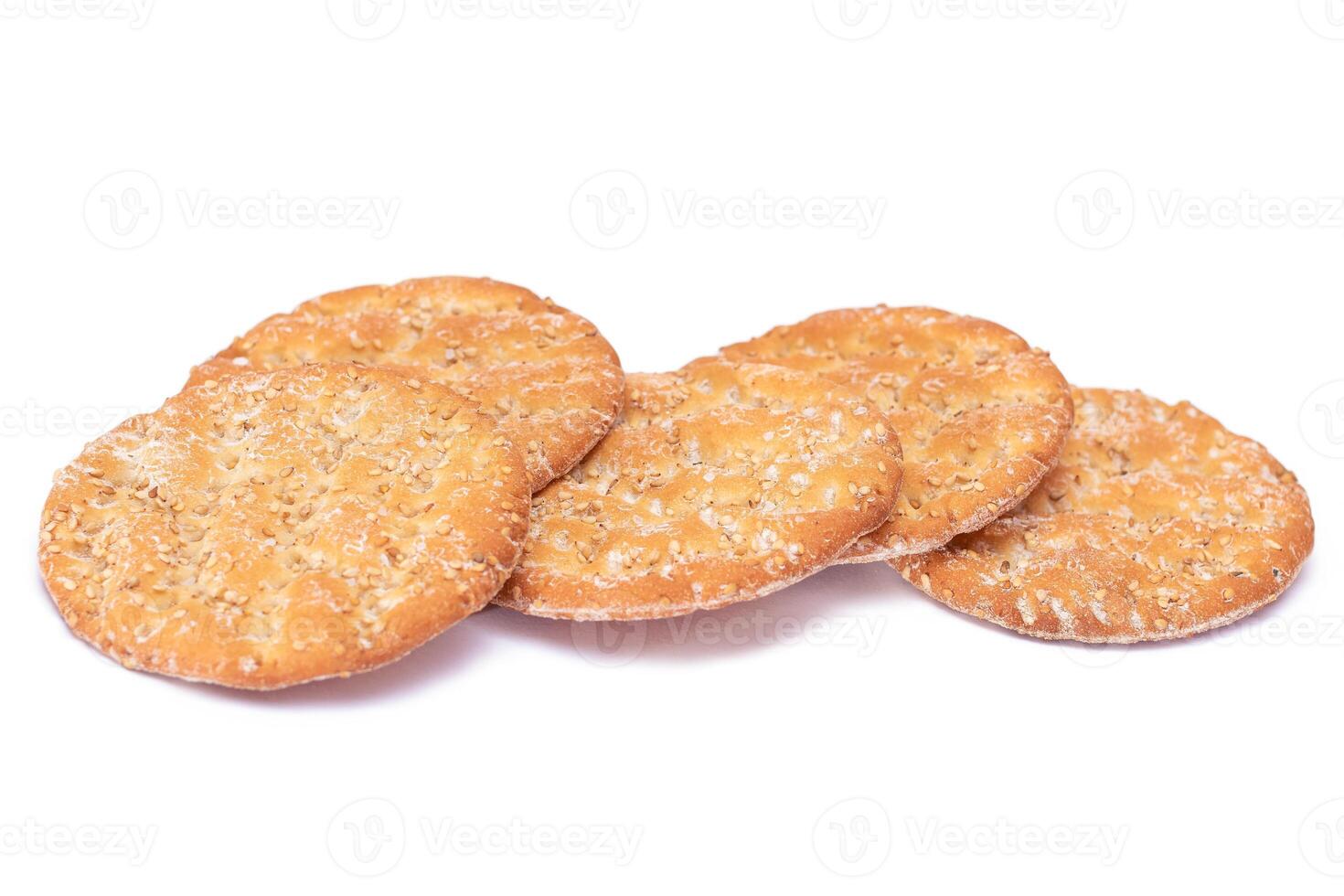 A Heap of Round Salt Crackers with Sesame Isolated on White Background. Dry Snacks - Isolation photo