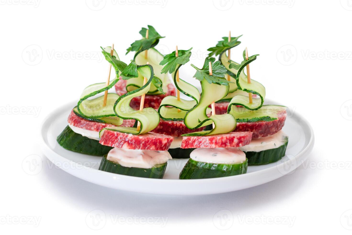 Canapes without Bread with Salami, Cucumber, Greens and Cream Cheese on White Plate - Isolated on White. Easy Breakfast. Diet Food. Quick and Healthy Sandwiches. Healthy Snacks with Tasty Fillings photo