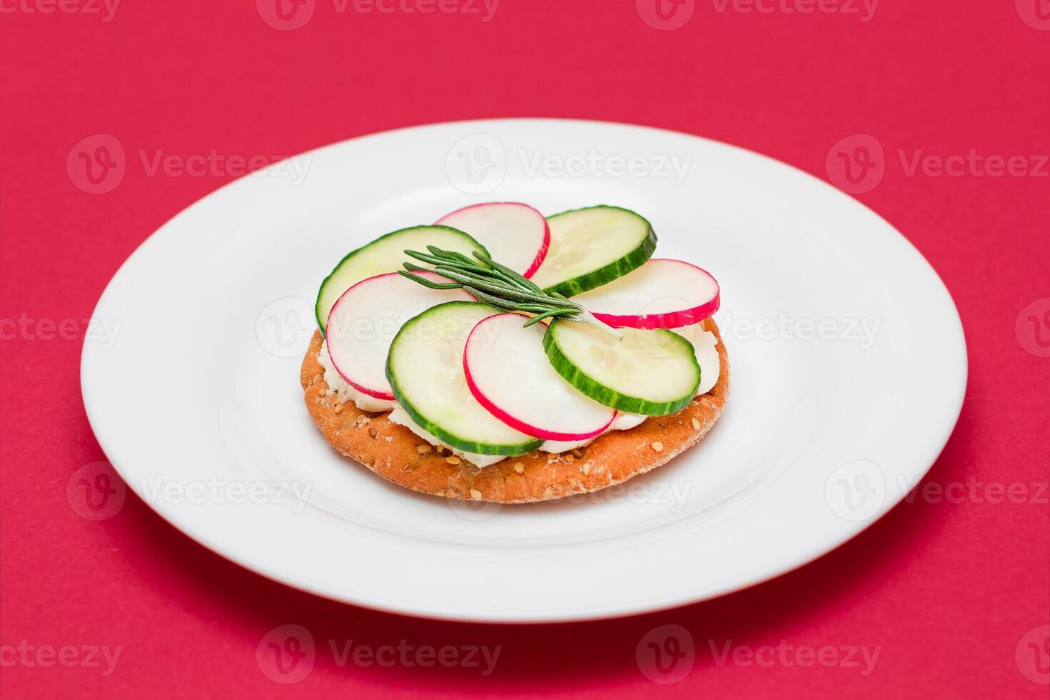 Crispy Cracker Sandwich with Cream Cheese, Fresh Cucumber and Radish on White Plate photo