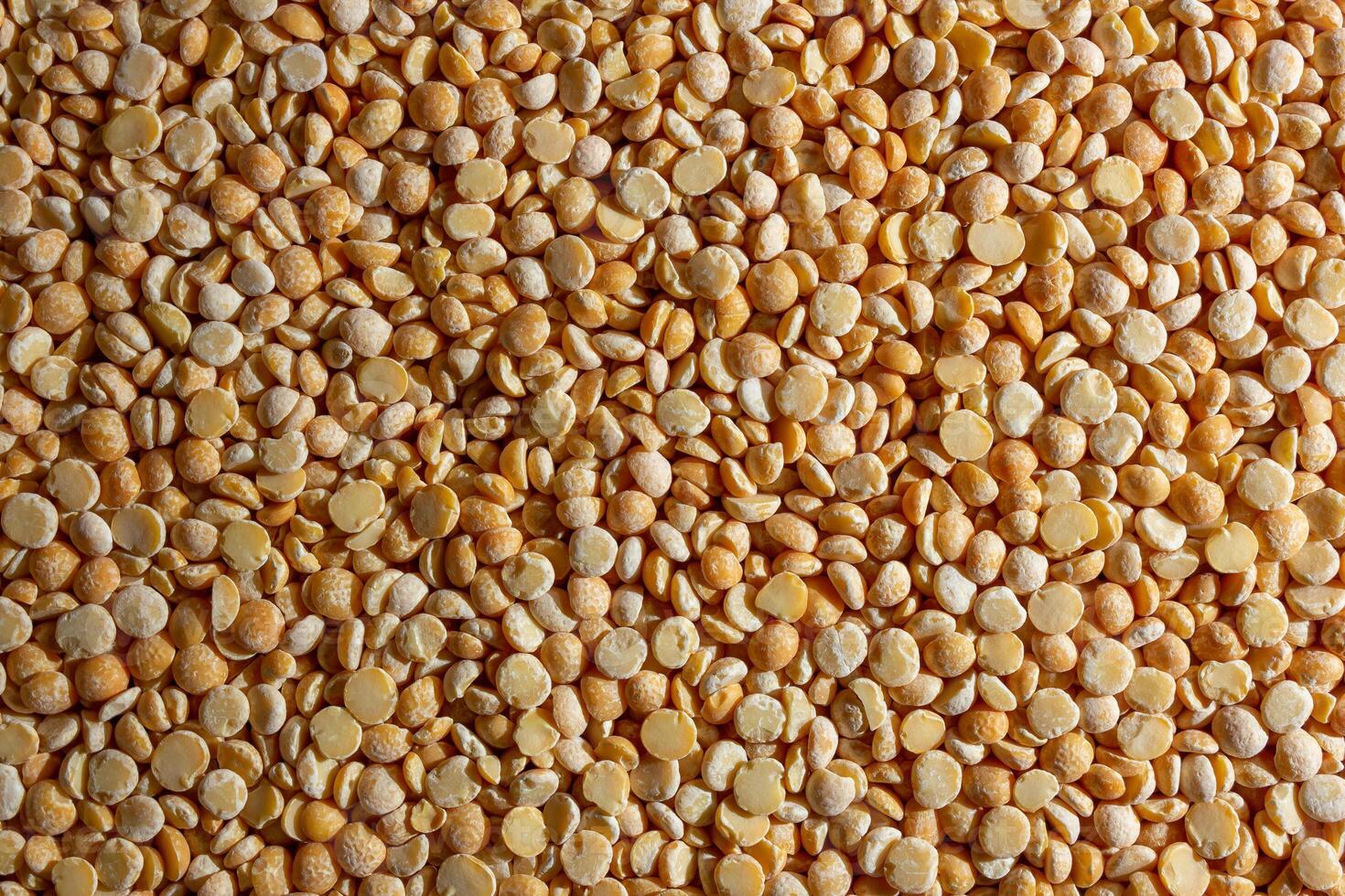 Uncooked Polished Split Peas Background. A Culinary Canvas of Dry Yellow Peas, Creating a Lively and Textured Background for Gourmet Cooking. Scattered Raw Polished Peas. Healthy Eating Ingredients photo