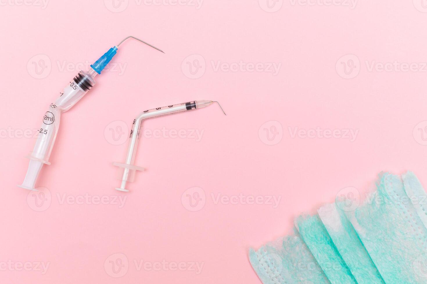 Anti Vaccine Movement and Anti Mask Concept - Broken Medical Syringe and Green Torn Medical Face Mask on the Pink Background. Pandemic and Lockdown End - Top View, Flat Lay photo