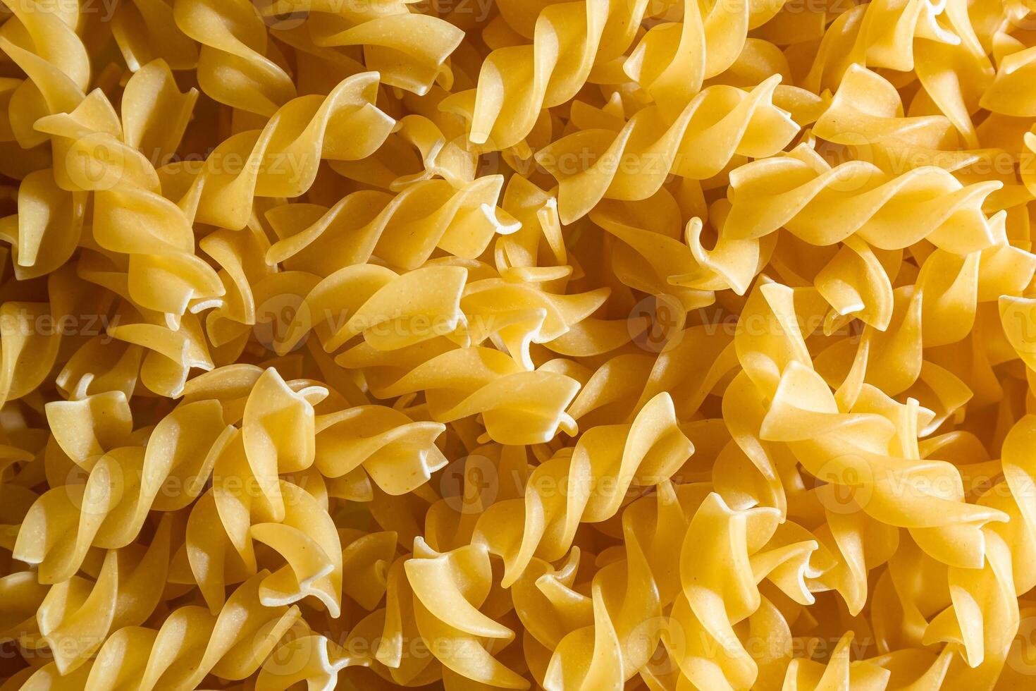 Uncooked Fusilli Pasta. A Culinary Canvas of Spiral Macaroni, Creating a Lively and Textured Background for Gourmet Cooking. Dry Pasta. Raw Macaroni - Top View, Flat Lay photo