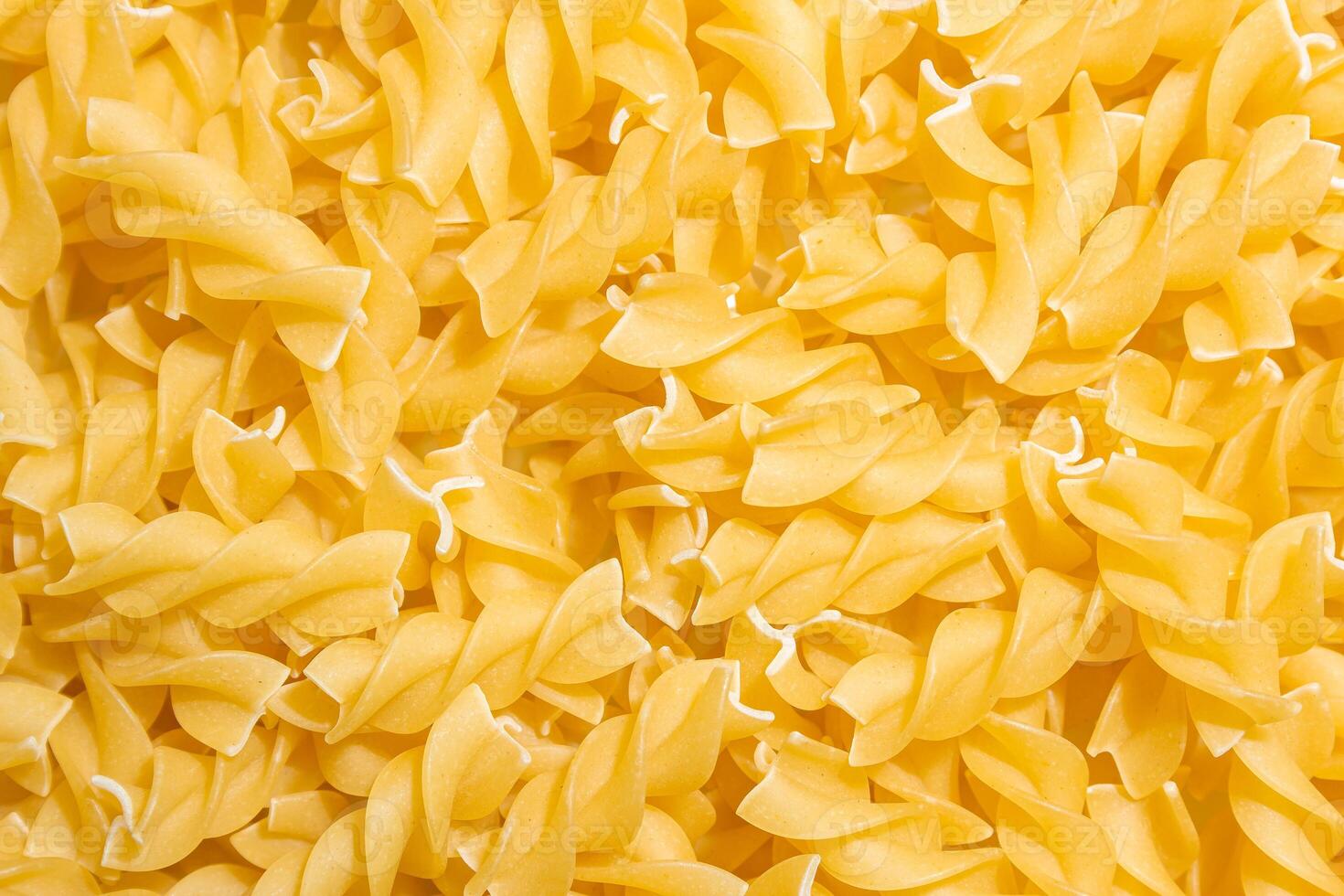 Uncooked Fusilli Pasta. A Culinary Canvas of Spiral Macaroni, Creating a Lively and Textured Background for Gourmet Cooking. Dry Pasta. Raw Macaroni - Top View, Flat Lay photo