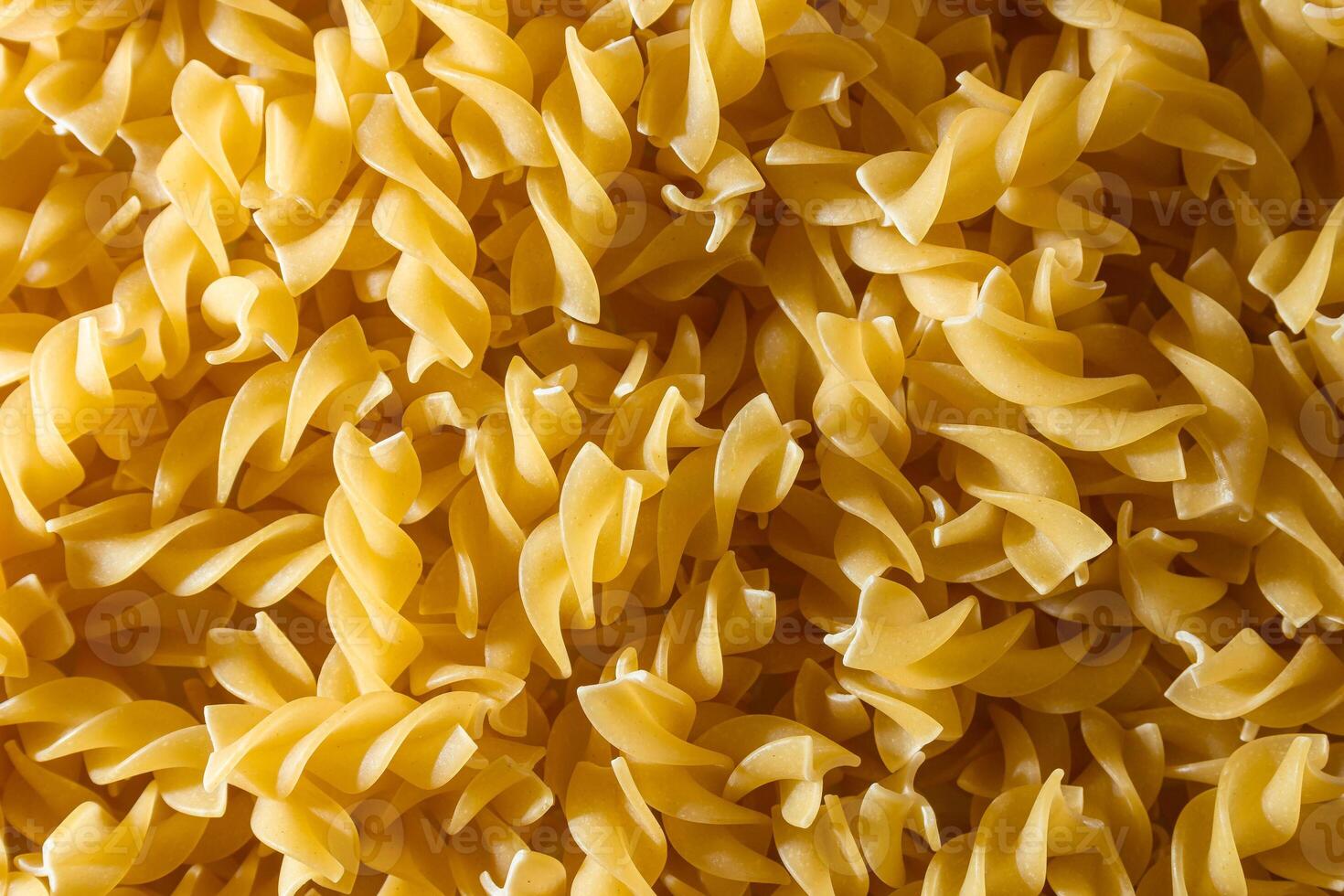 Uncooked Fusilli Pasta. A Culinary Canvas of Spiral Macaroni, Creating a Lively and Textured Background for Gourmet Cooking. Dry Pasta. Raw Macaroni - Top View, Flat Lay photo