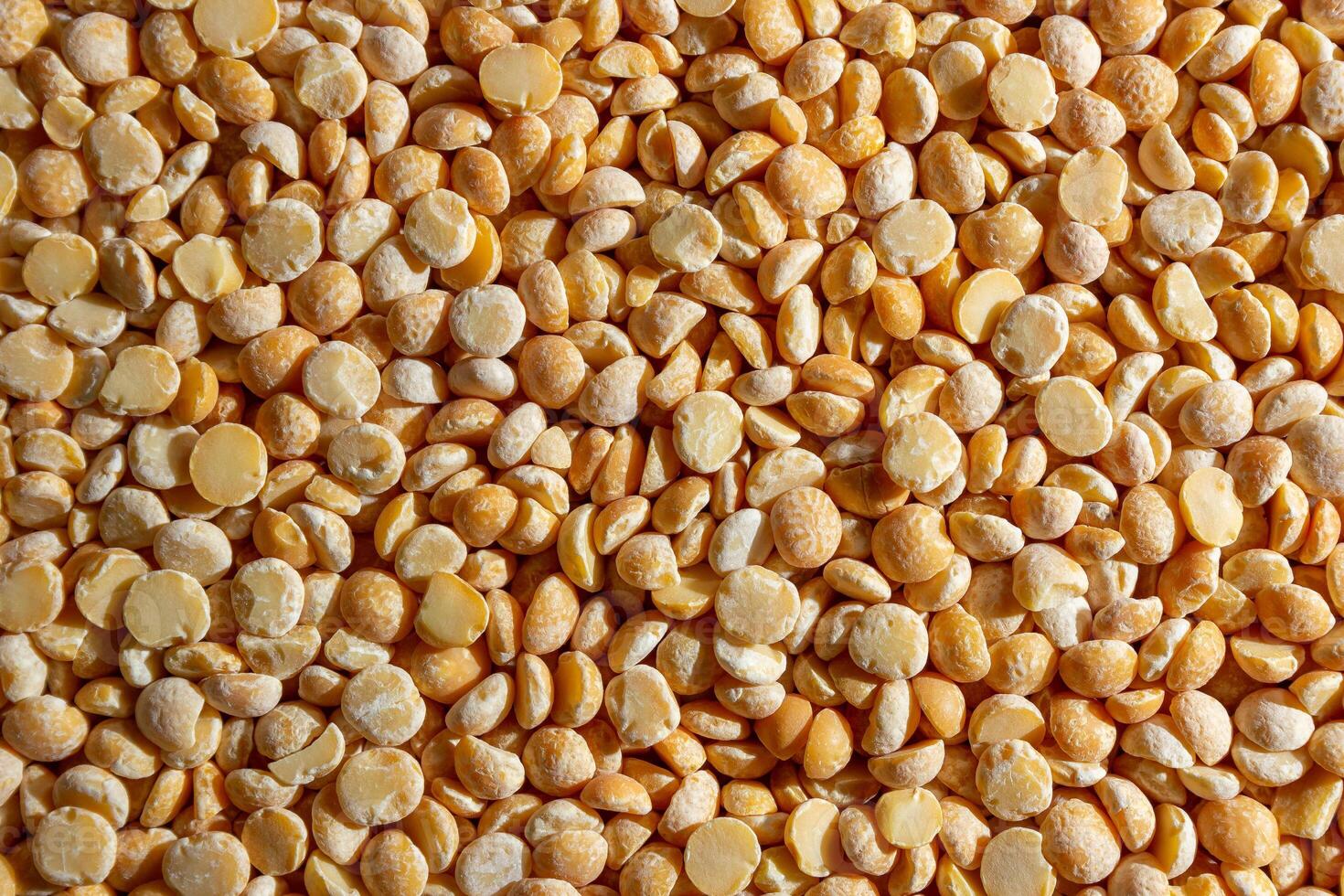 Uncooked Polished Split Peas Background. A Culinary Canvas of Dry Yellow Peas, Creating a Lively and Textured Background for Gourmet Cooking. Scattered Raw Polished Peas. Healthy Eating Ingredients photo