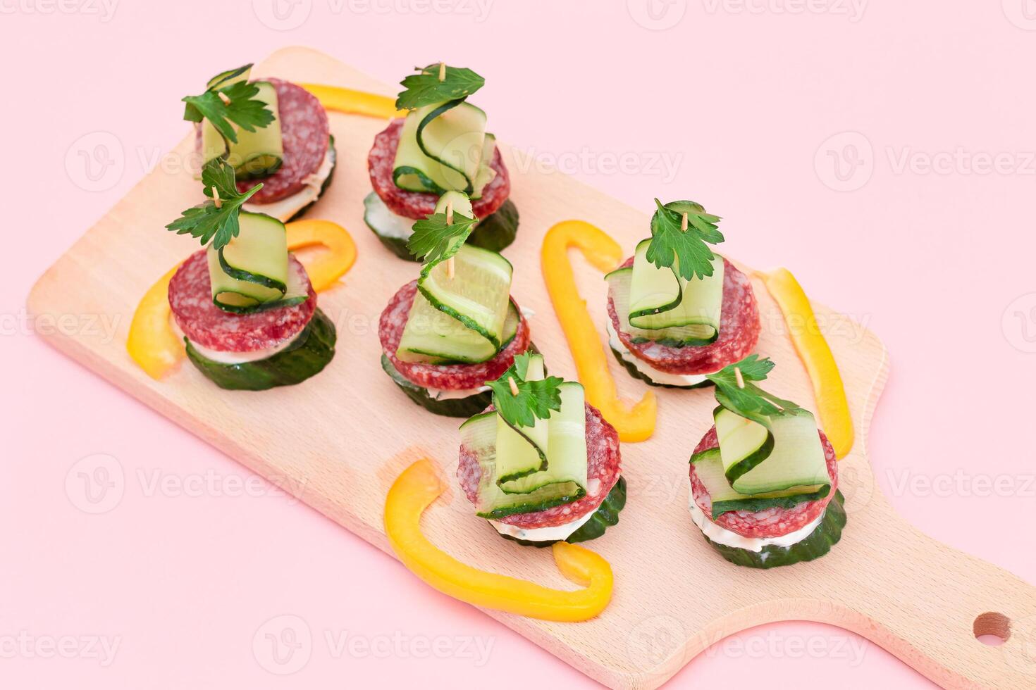 Canapes without Bread with Salami, Cucumber, Greens and Cream Cheese on Wooden Cutting Board. Easy Breakfast. Diet Food. Quick and Healthy Sandwiches. Healthy Snacks with Tasty Fillings photo
