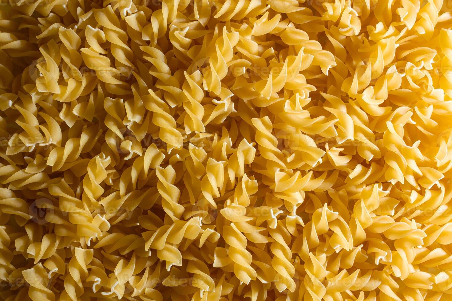Uncooked Fusilli Pasta. A Culinary Canvas of Spiral Macaroni, Creating a Lively and Textured Background for Gourmet Cooking. Dry Pasta. Raw Macaroni - Top View, Flat Lay photo