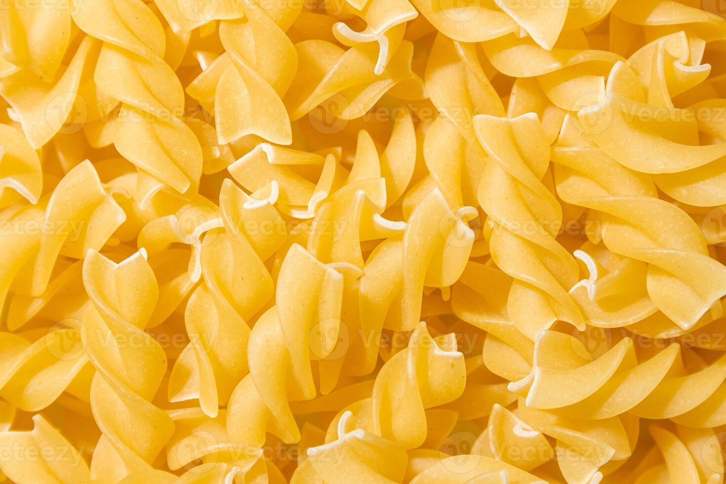 Uncooked Fusilli Pasta. A Culinary Canvas of Spiral Macaroni, Creating a Lively and Textured Background for Gourmet Cooking. Dry Pasta. Raw Macaroni - Top View, Flat Lay photo