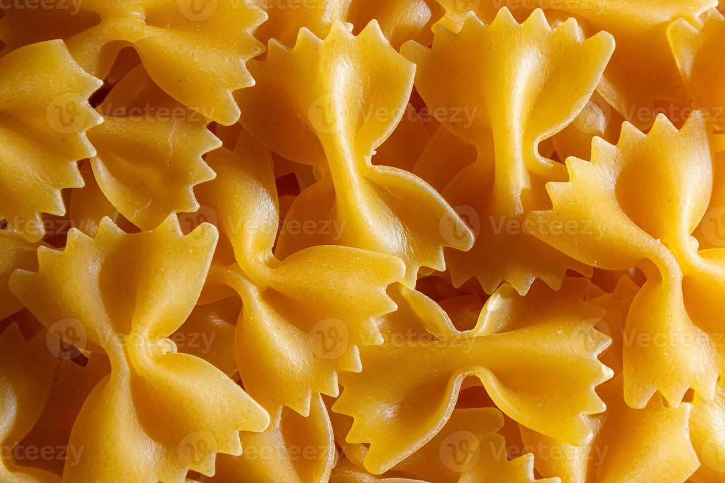 Uncooked Farfalle Pasta. A Culinary Canvas of Bow-Tie Macaroni, Creating a Lively and Textured Background for Gourmet Cooking. Dry Pasta. Raw Macaroni - Top View, Flat Lay photo