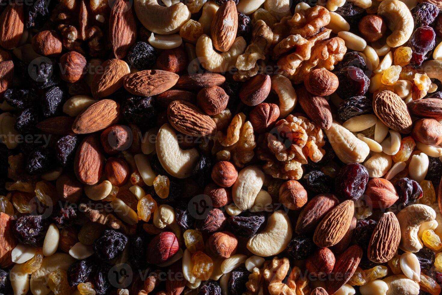 Mixed Nuts. Almonds, Walnuts, Cashews, Peanuts, Hazelnuts, Dried Prunes and Raisins. Different Nut Mix. Background from Various Nuts and Dried Fruits photo