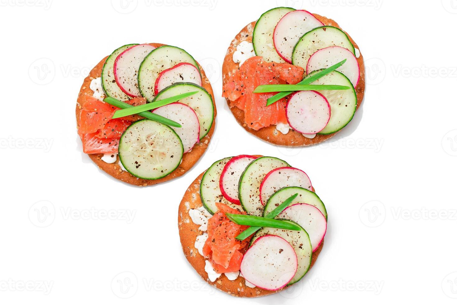 Crispy Cracker Sandwiches with Salmon, Cucumber, Radish, Cottage Cheese and Green Onions - Isolated on White. Easy Breakfast. Quick and Healthy Sandwiches. Crispbread with Tasty Filling - Isolation photo