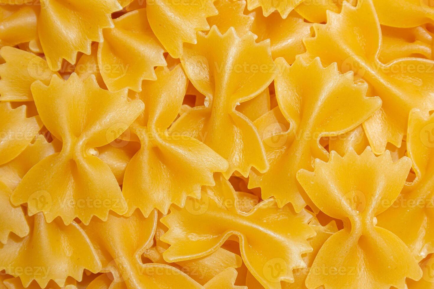 Uncooked Farfalle Pasta. A Culinary Canvas of Bow-Tie Macaroni, Creating a Lively and Textured Background for Gourmet Cooking. Dry Pasta. Raw Macaroni - Top View, Flat Lay photo
