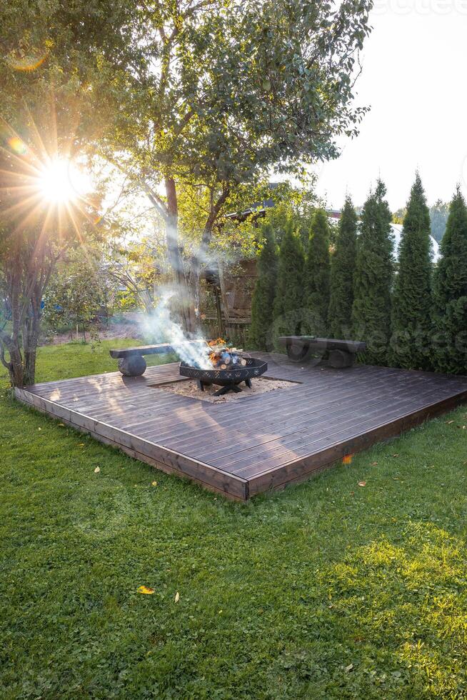 Outdoor Wooden Deck with Central Fire Pit and Rustic Benches photo