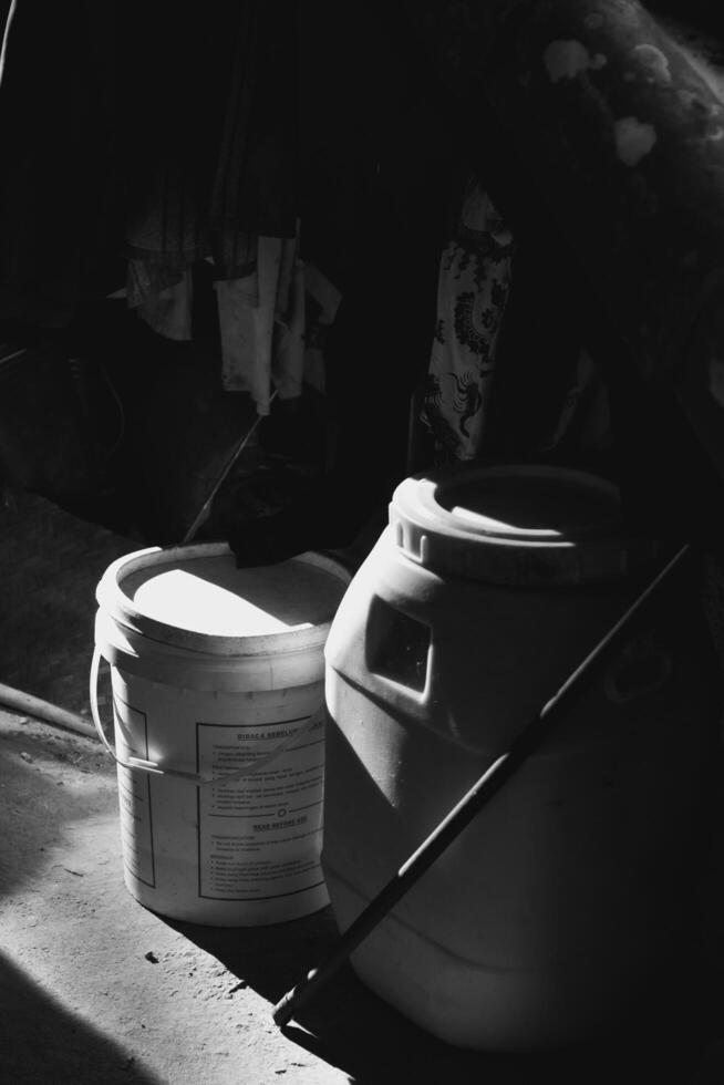 2 black and white trash cans illuminated by light from the side photo