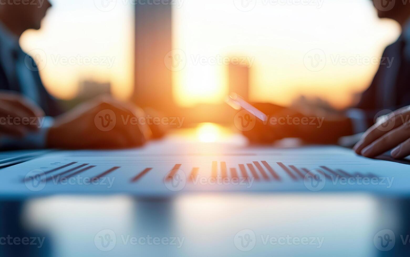 Group of professionals discussing financial reports during sunset, highlighting teamwork and analysis in conference room photo