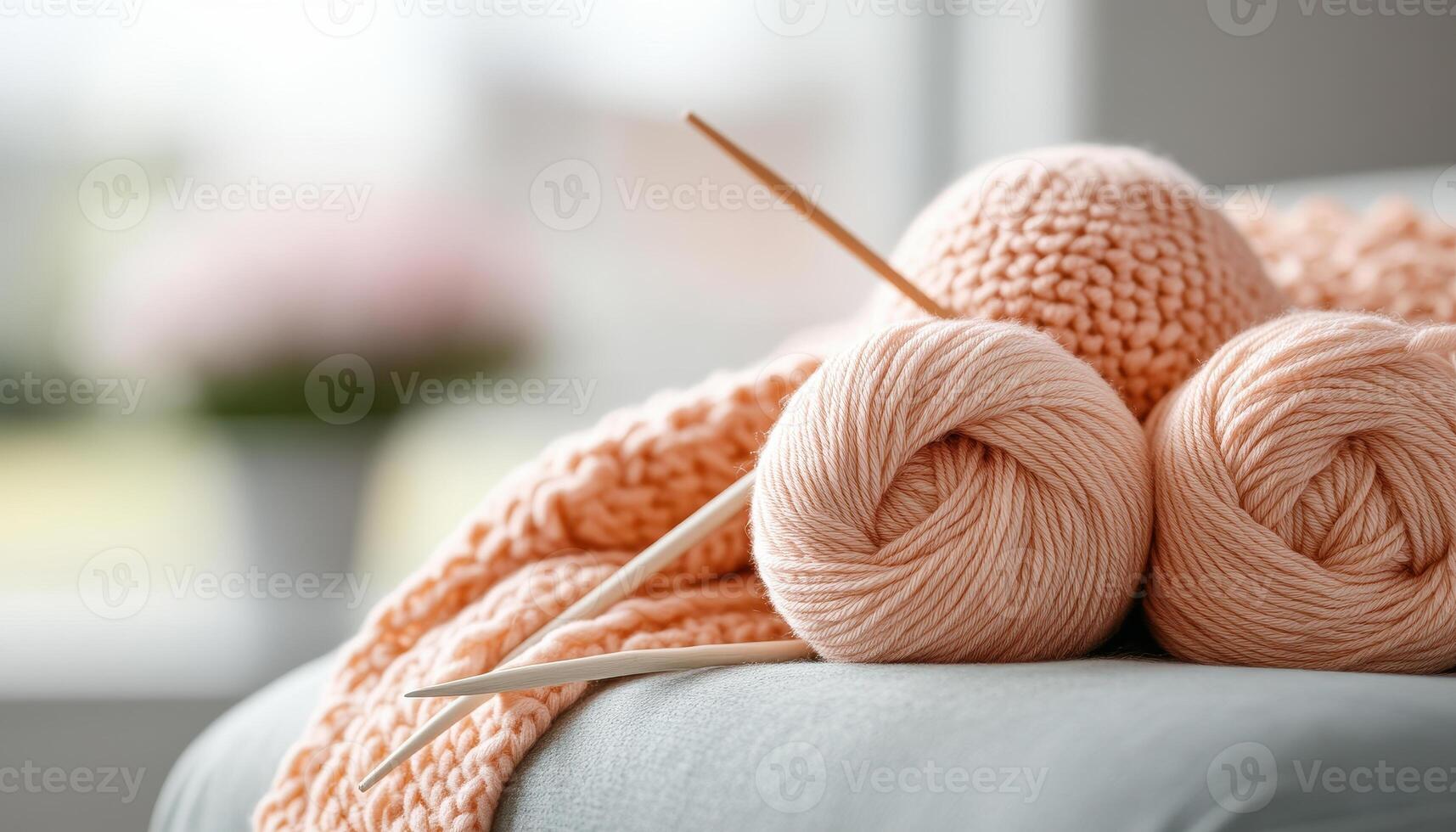Knitting project in progress with soft peach yarn and wooden needles, creating cozy atmosphere. Perfect for crafting enthusiasts and home decor lovers photo
