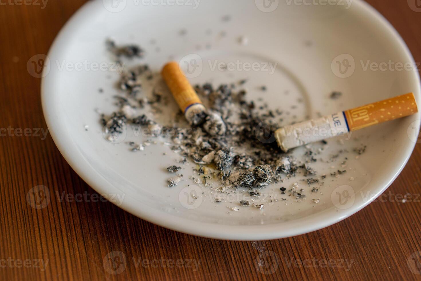 closeup of smoking ashtray with ashes and broken cigarette photo