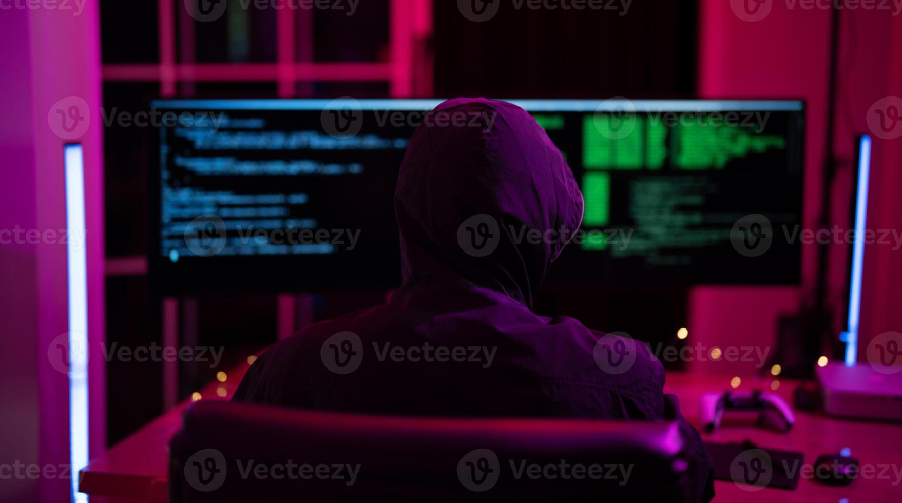 Black Hat Hacker hoodie concept at a laptop computer hacking the Internet. Cyber crime and security principles. photo