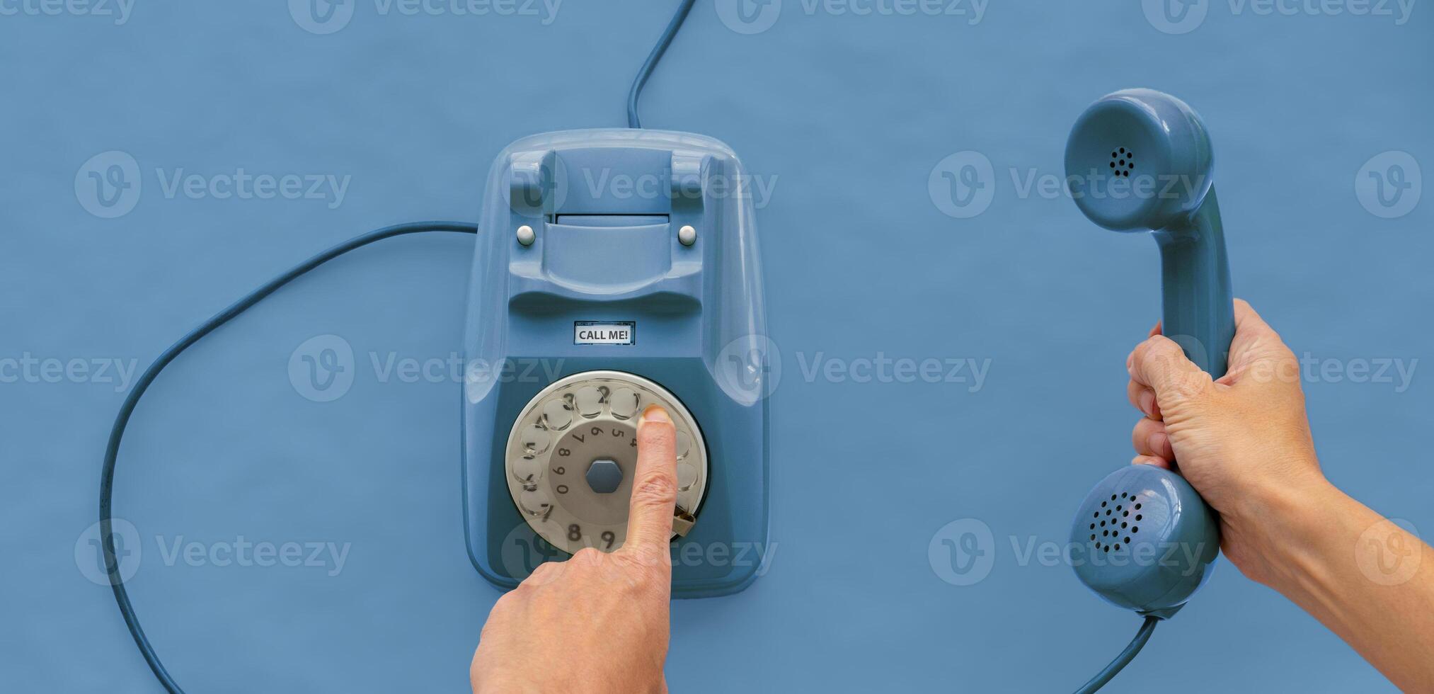 A vintage dial telephone handset with one hand and background. photo