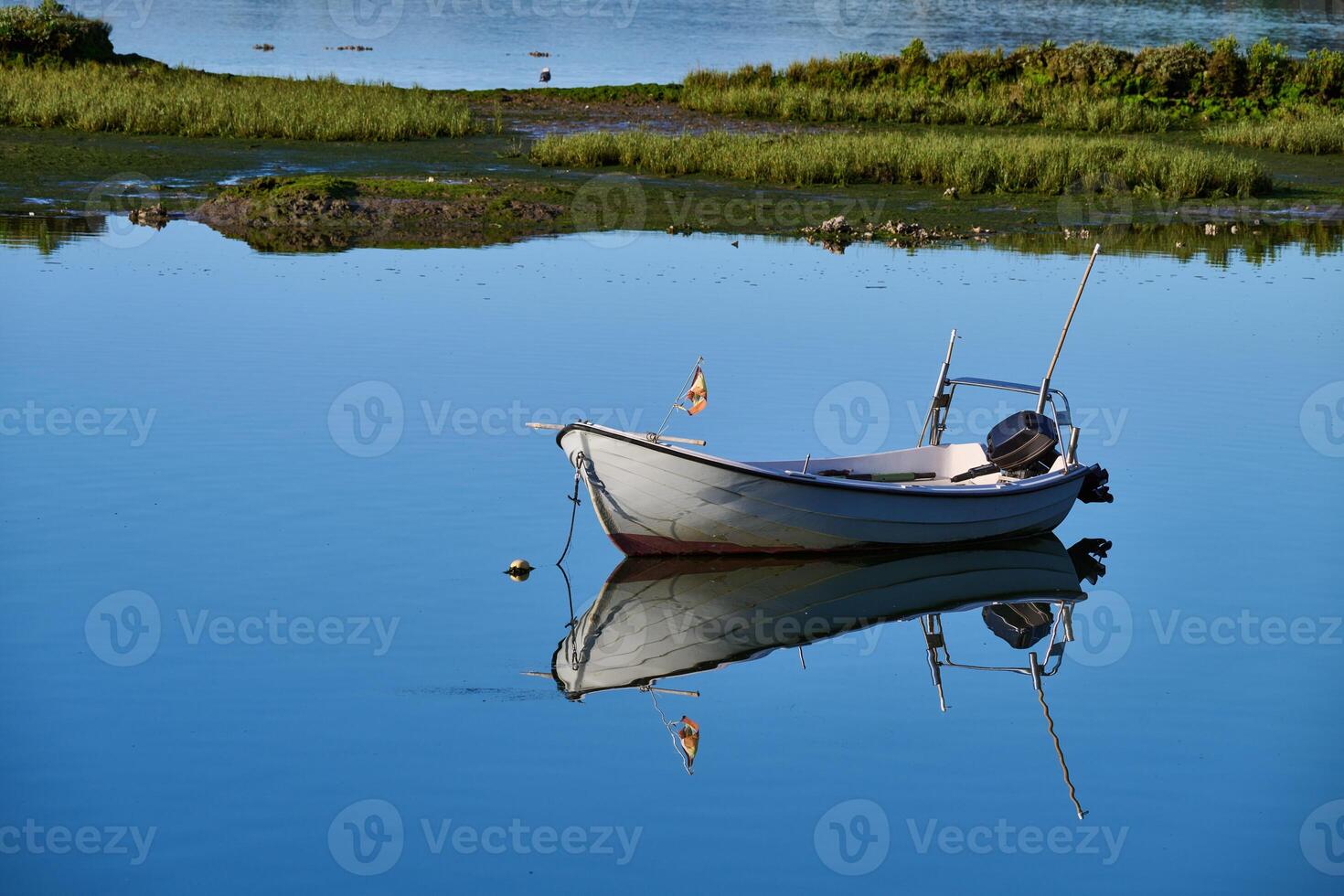 Small fishing boat with outboard motor moored photo