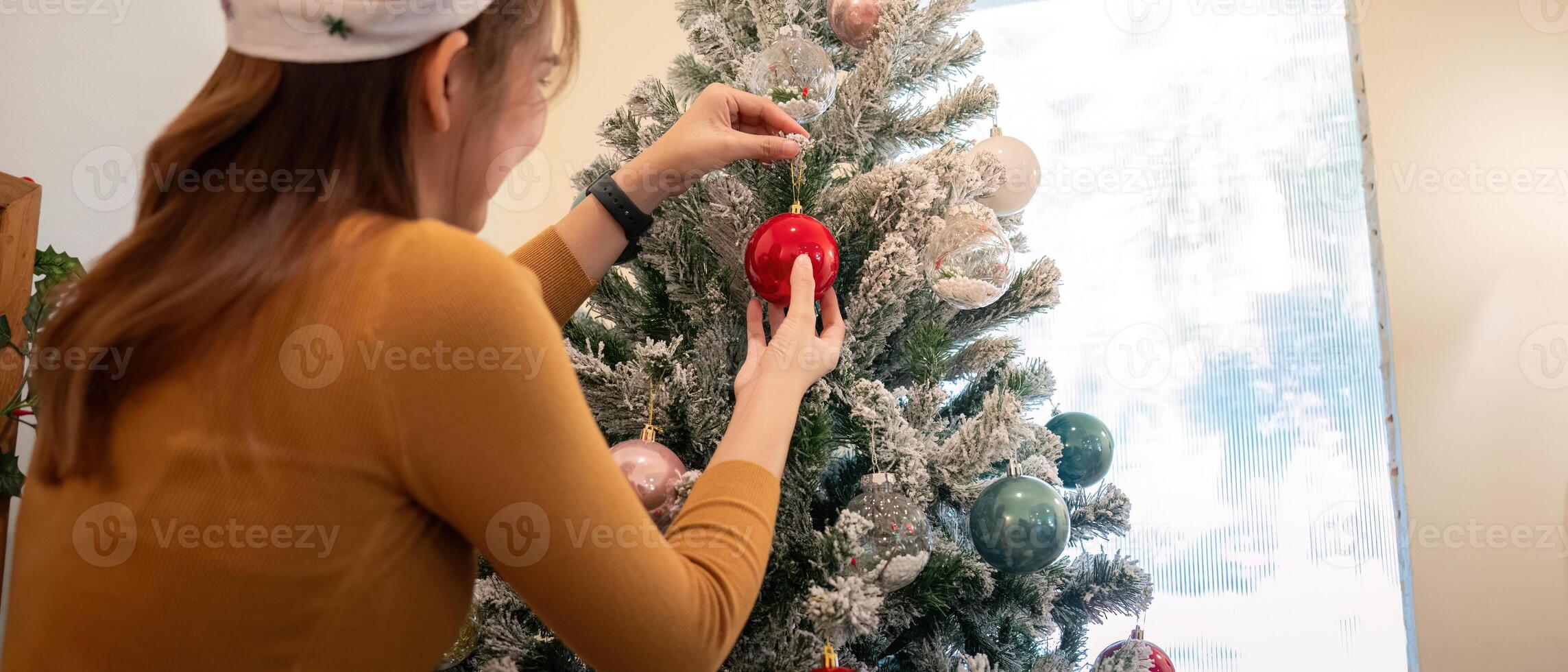 Woman Decorating Christmas Tree as Holiday Festivity Approaches photo