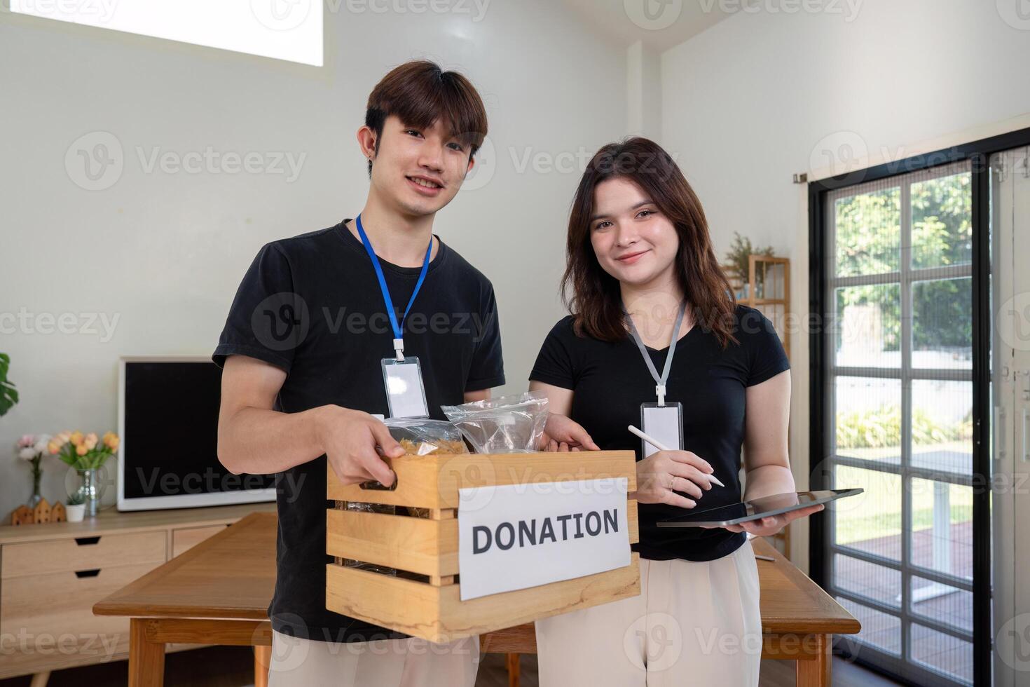 Smiling Volunteers Promoting Charitable Efforts with Donation Boxes photo