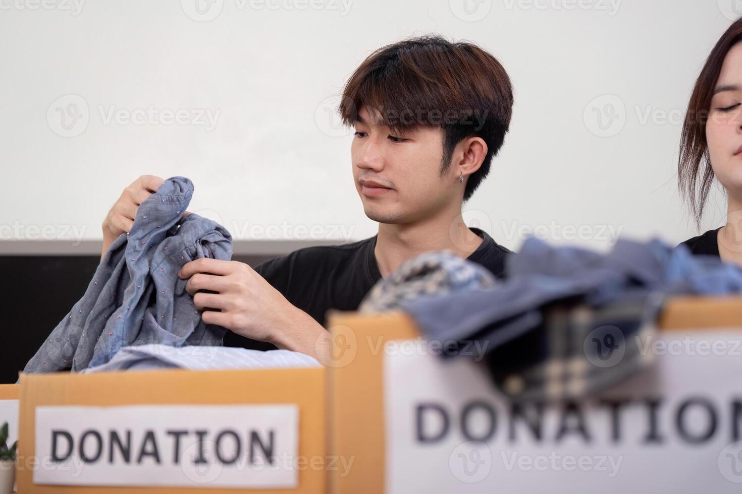 Volunteer Engaged in Organizing Clothing Donations for Charity photo
