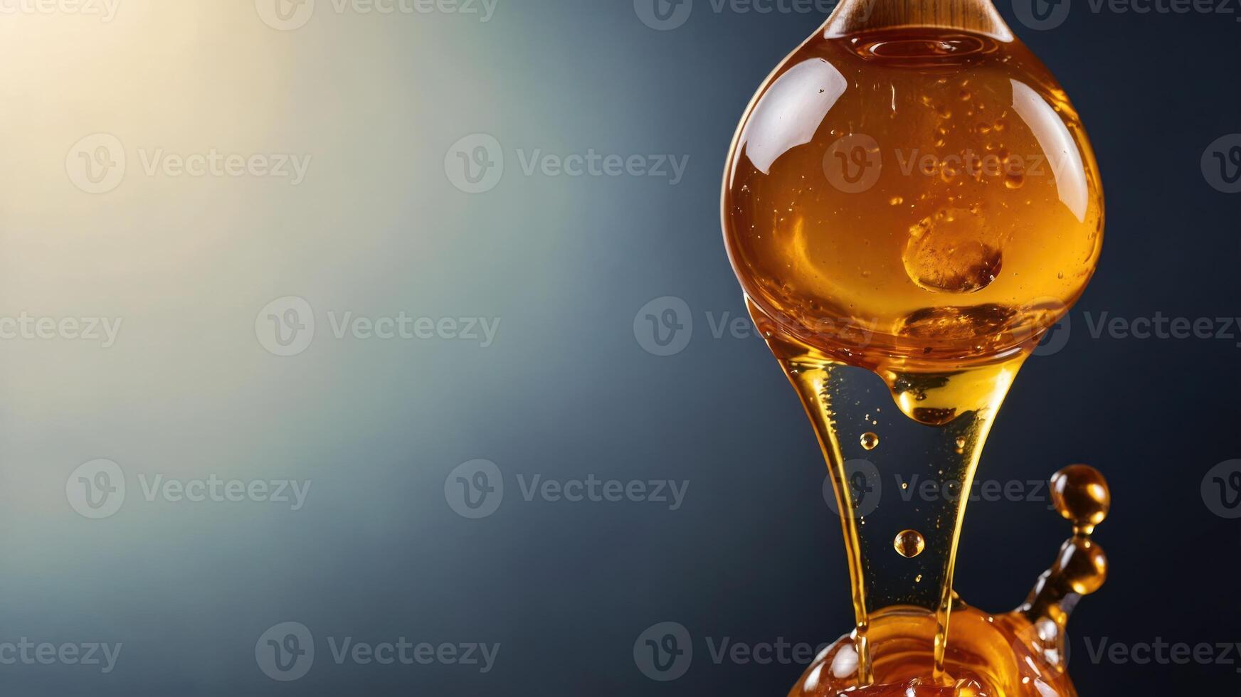 A close-up of golden liquid dripping from a round glass apparatus. photo