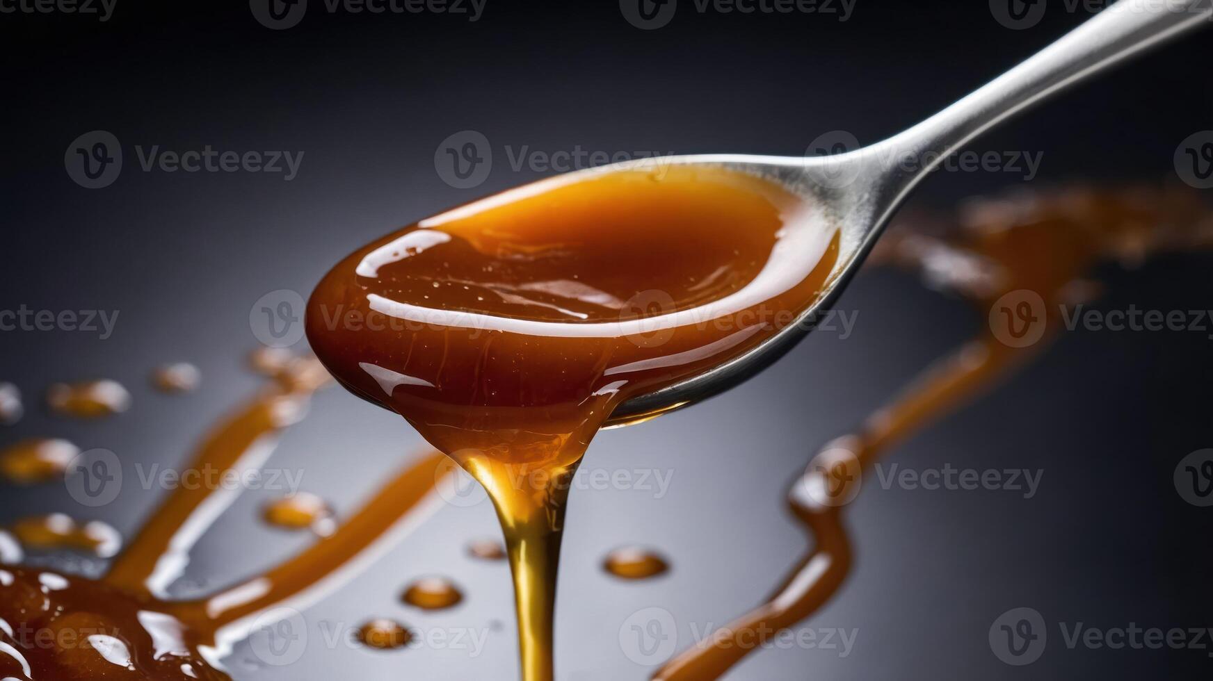 A close-up of syrup dripping from a spoon, showcasing its glossy texture and rich color. photo