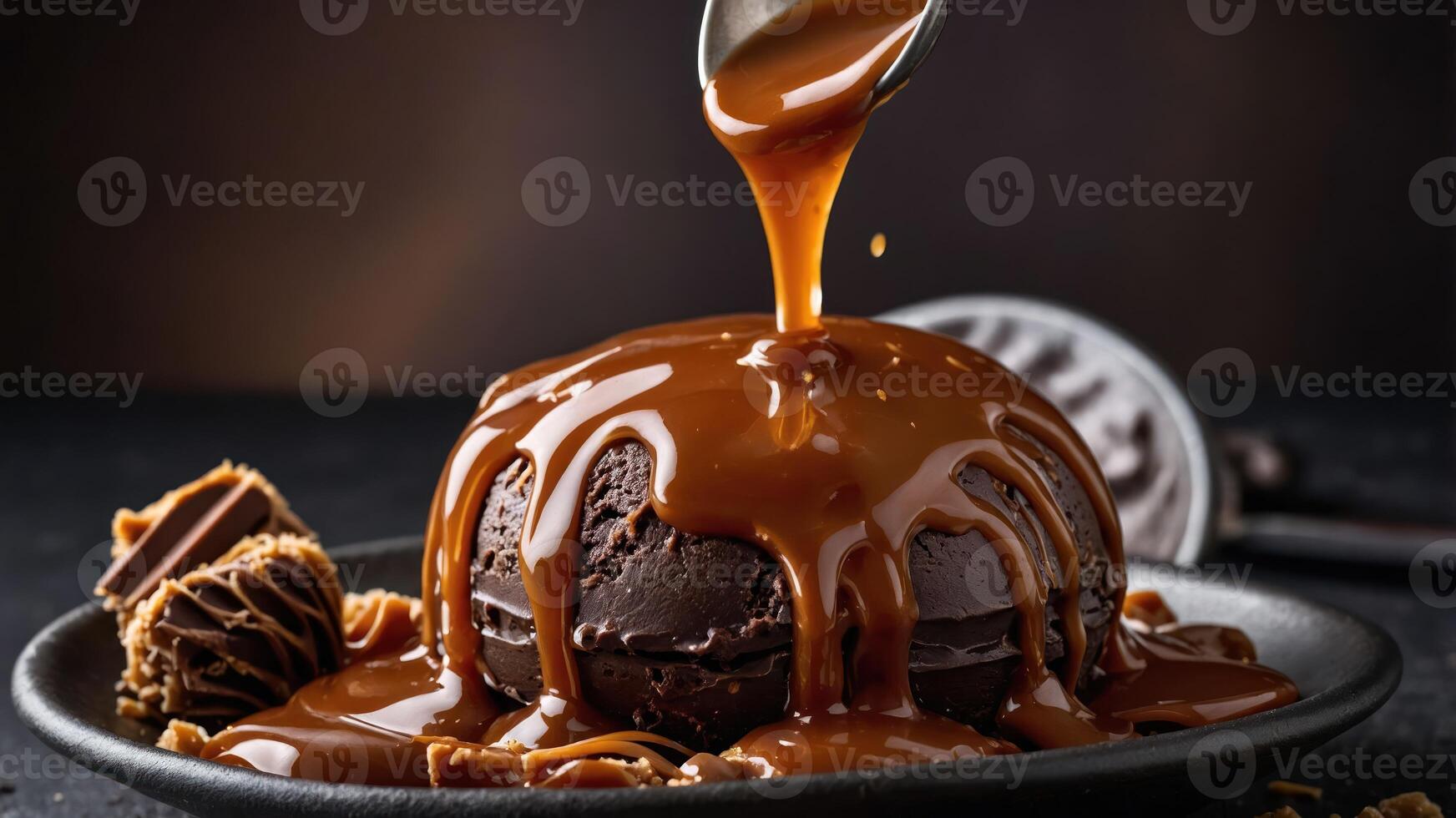 A decadent chocolate dessert topped with rich caramel sauce, served on a dark plate. photo