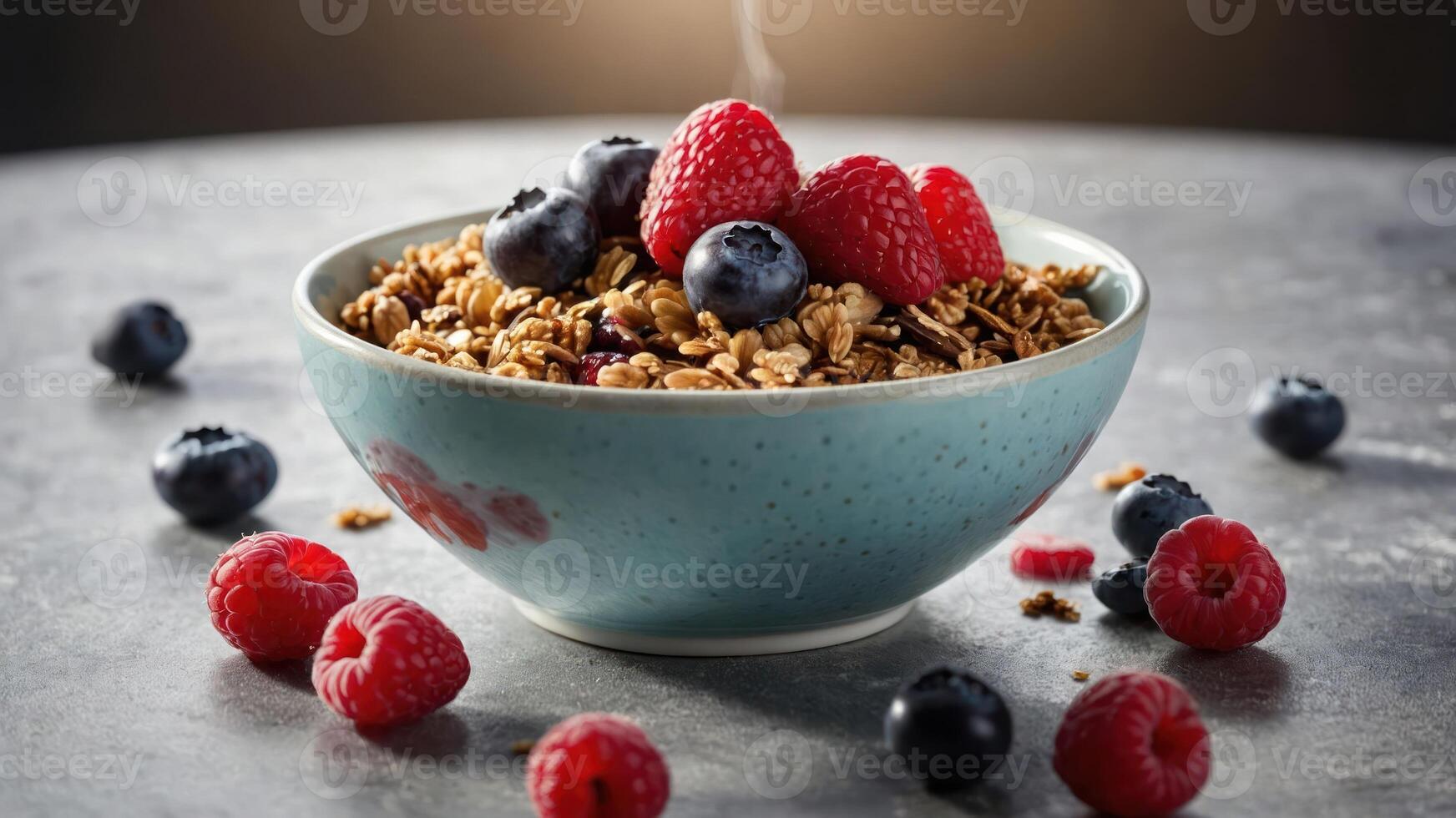 A bowl of granola topped with fresh raspberries and blueberries, set on a textured surface. photo