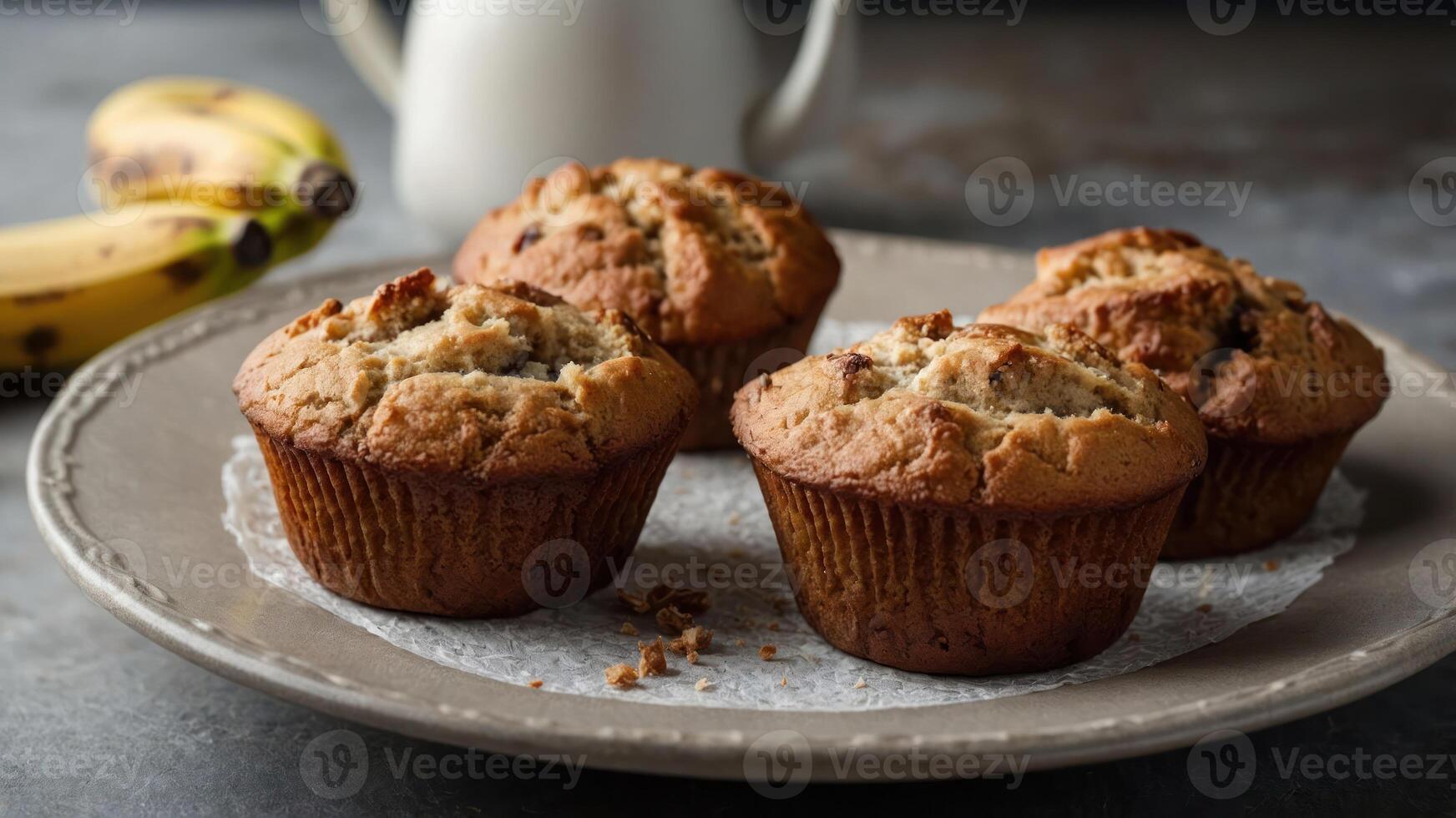 Freshly baked muffins on a plate with bananas in the background. photo