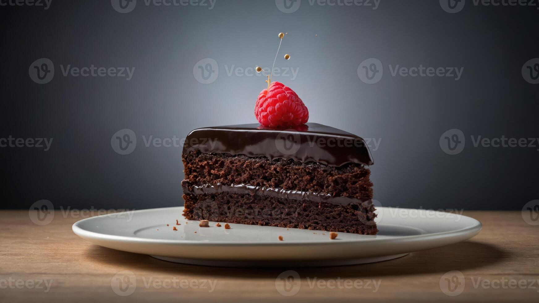 A slice of rich chocolate cake topped with a raspberry on a plate against a dark background. photo