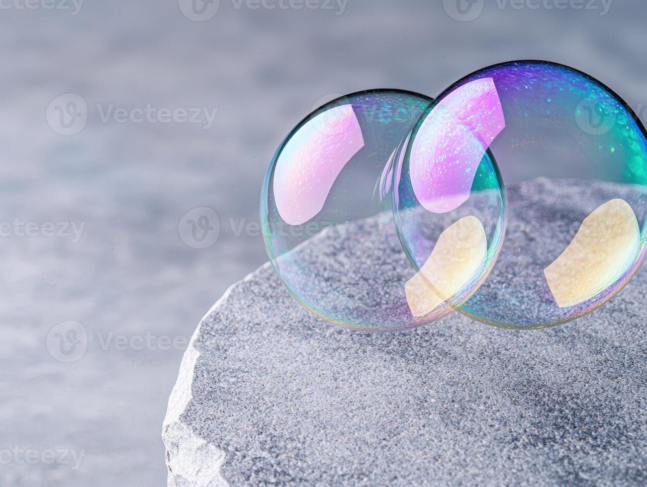 Colorful soap bubbles on a rocky surface photo