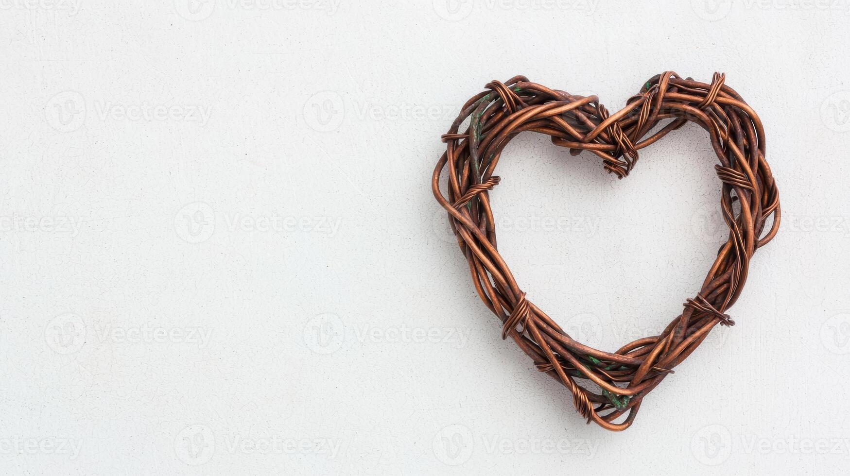 Handmade woven heart shaped wreath on plain background photo